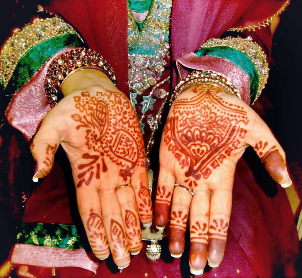 Livestream Asian Weddings Decorative henna tattoos on an Indian woman's hands.
