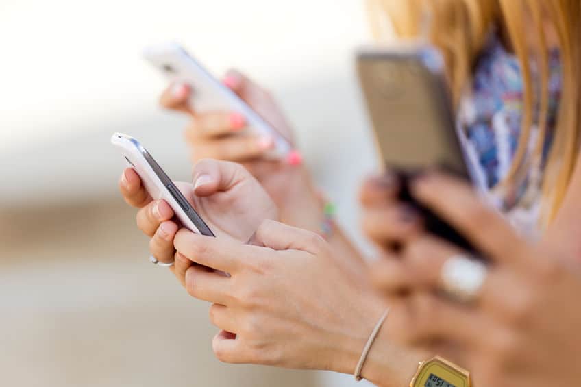 Multiple mobile phone users using their phones all at the same time.