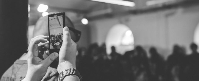 Woman taking a photo with cell phone / bw